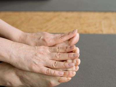 Close-up of feet in training shoes on a yoga mat.